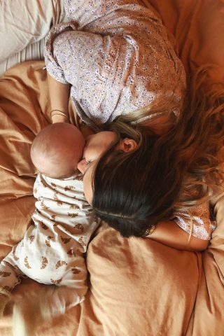 baby og mor ligger på sengen