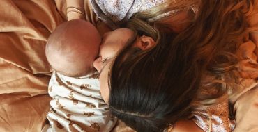 baby og mor ligger på sengen